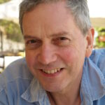 Head and shoulders photo of Robert Culshaw, wearing a blue open necked shirt